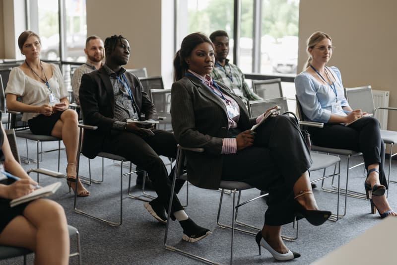 Teilnehmende eines Seminars hören einem Vortrag zu